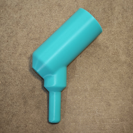 Der New Plastics Stifthalter für Ideen mit Herz E-Painter ist ein blaugrüner, ergonomischer Stifthalter aus Kunststoff mit abgewinkelter zylindrischer Spitze und geradem Griff auf einer strukturierten braunen Oberfläche. Kompatibel mit dem E-Painter für mehr Vielseitigkeit.