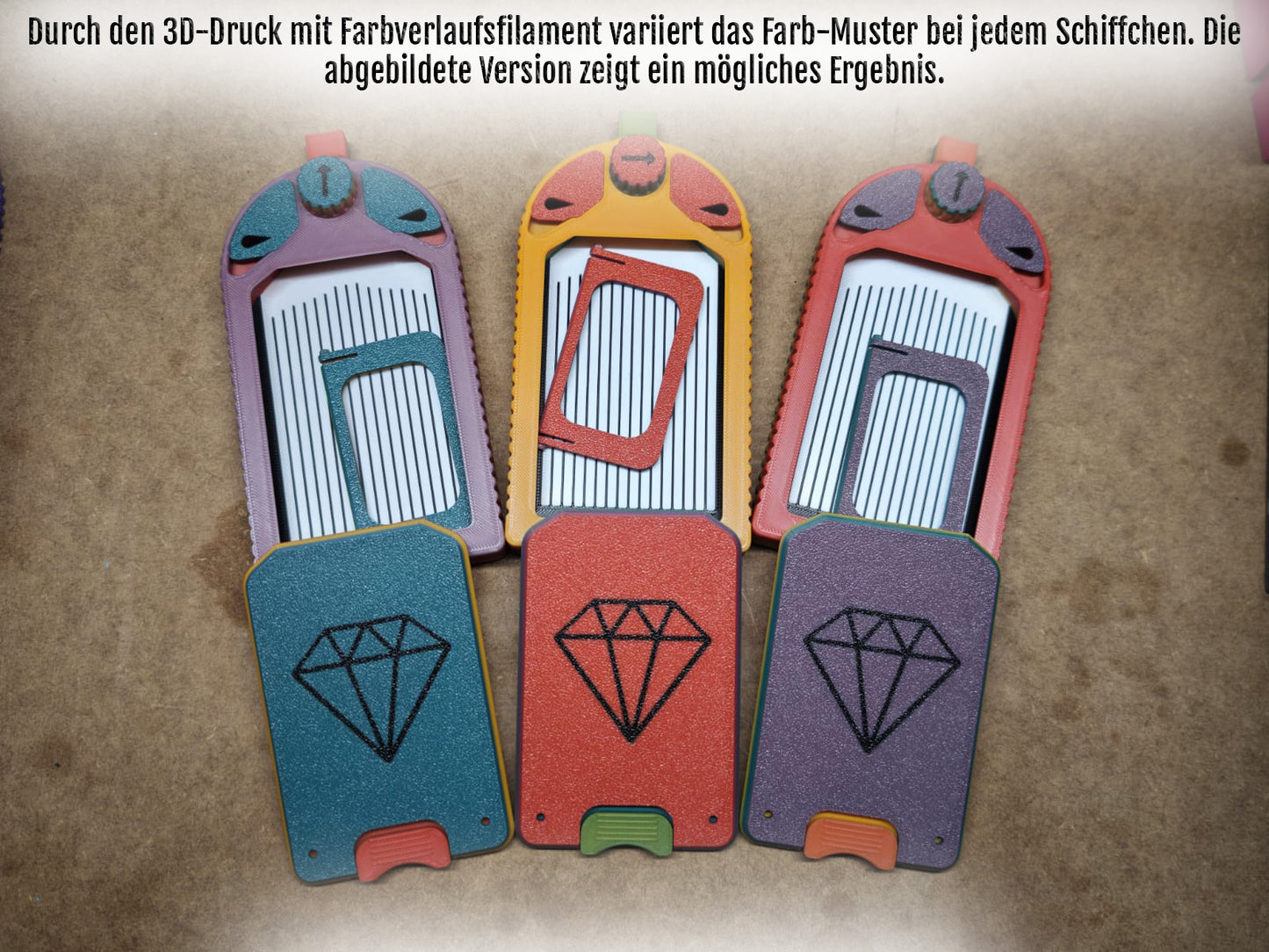 Vier mehrfarbige Käsehobel mit edelsteinartigen Griffen werden kunstvoll präsentiert, ähnlich dem Diamond Painting Schiffchen S1 PLUS von New Plastics, mit leuchtenden Farbverläufen. Ihr 3D-gedrucktes Design und die Farbvariationen erzeugen nebeneinander einen schillernden künstlerischen Eindruck.