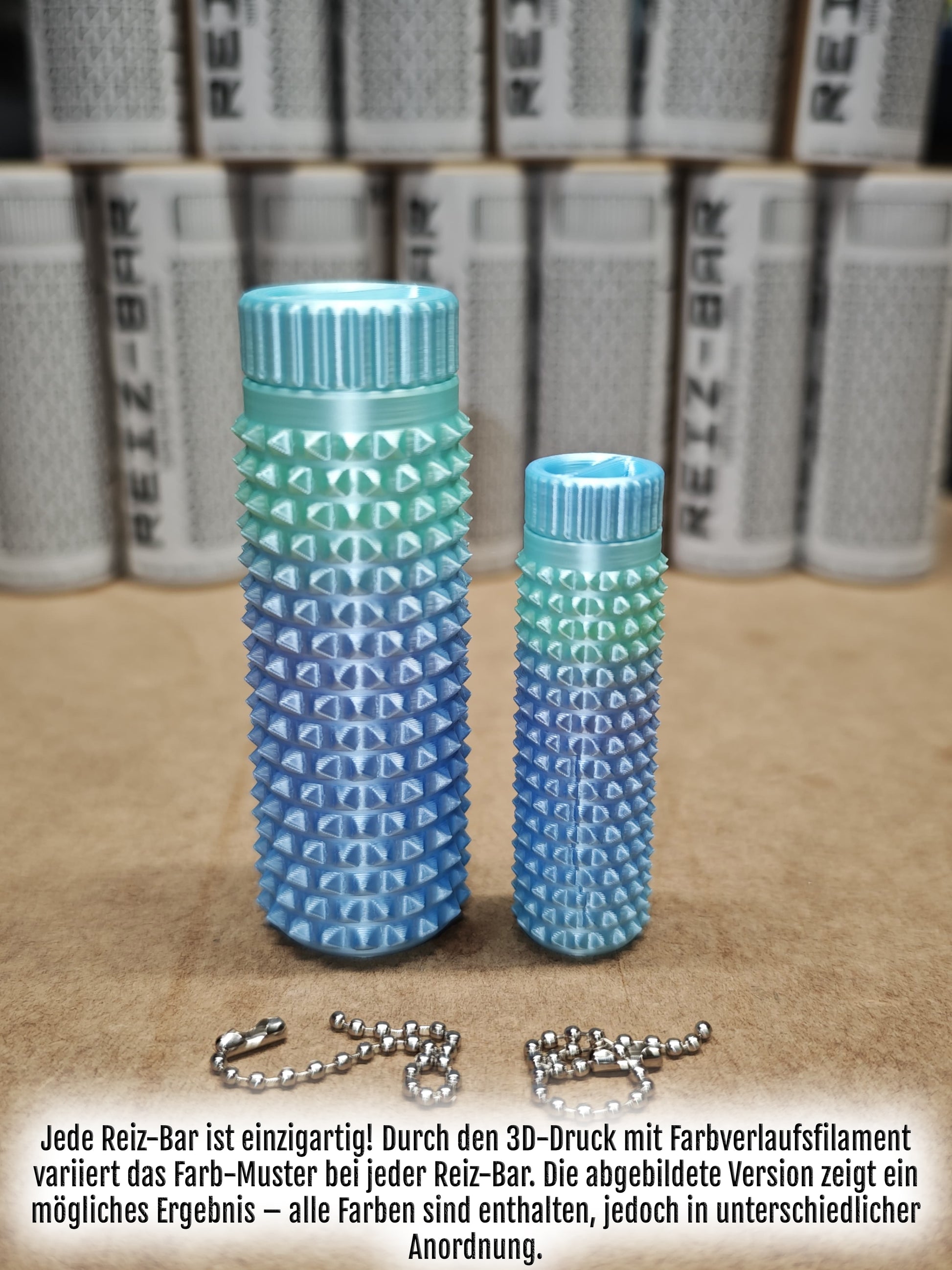 Das Reiz-Bar-Set von New Plastics besteht aus zwei vertikal angeordneten zylindrischen, strukturierten Objekten in reinem Blau, die ein subtiles taktiles Erlebnis bieten. In der Nähe befindet sich eine zerbrochene Metallkette, während im Hintergrund teilweise verdeckte und unscharfe zylindrische Behälter zu sehen sind.