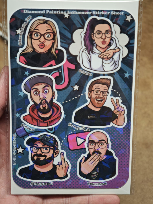 Eine Hand zeigt den New Plastics Diamond Painting „Influencer“ Stickerbogen (ca. DIN A6) mit 6 ausdrucksstarken Charakter-Stickern auf blauem Starburst-Hintergrund – ideal für DIY-Projekte, jeweils inklusive Social-Media-Handle.