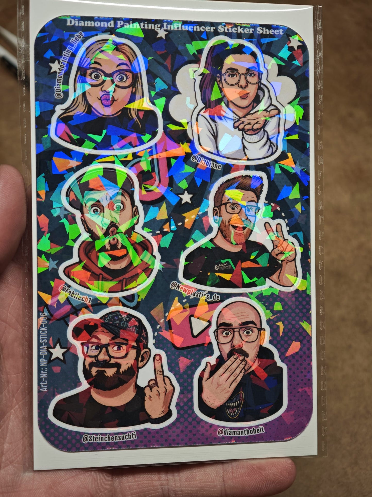 Das Diamond Painting „Influencer“ Sticker Sheet von New Plastics enthält 6 ca. DIN A6 Aufkleber mit ausdrucksstarken Cartoon-Porträts, ideal für DIY-Projekte.