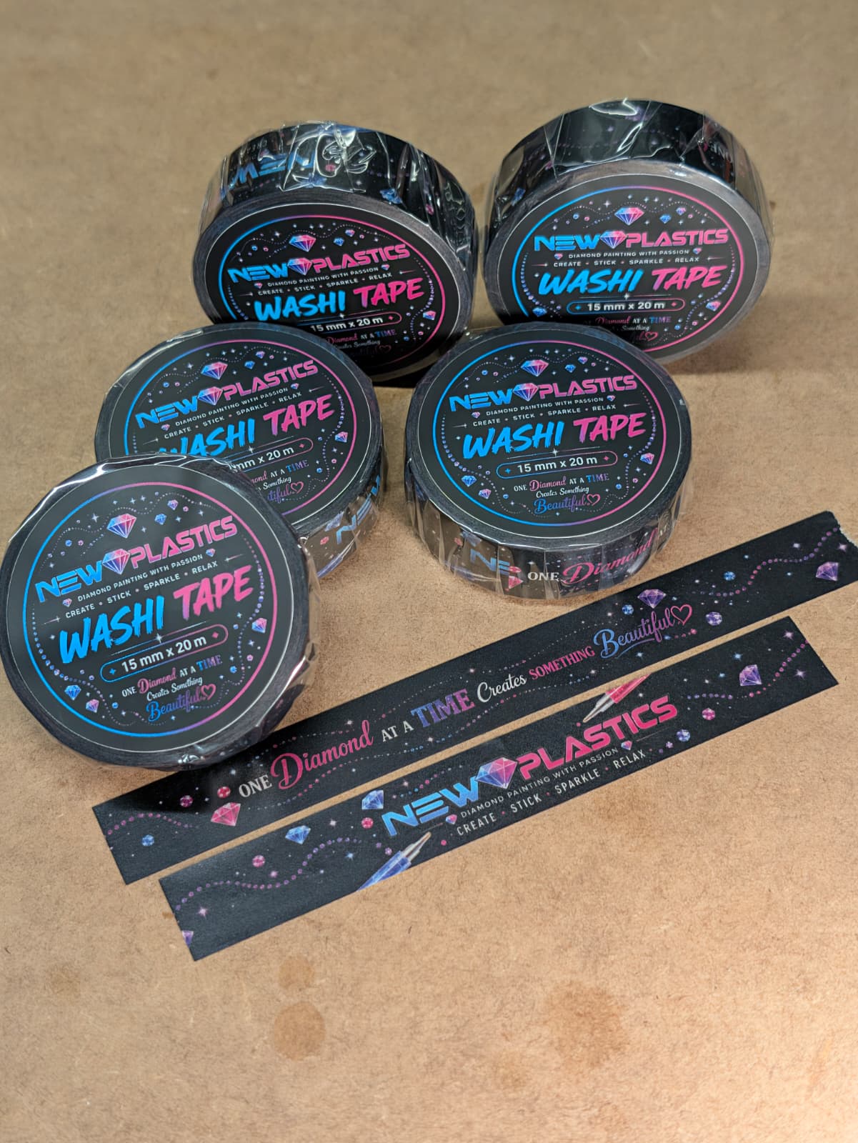 Fünf Rollen Washi Tape von New Plastics mit zwei abgerissenen Bandstücken